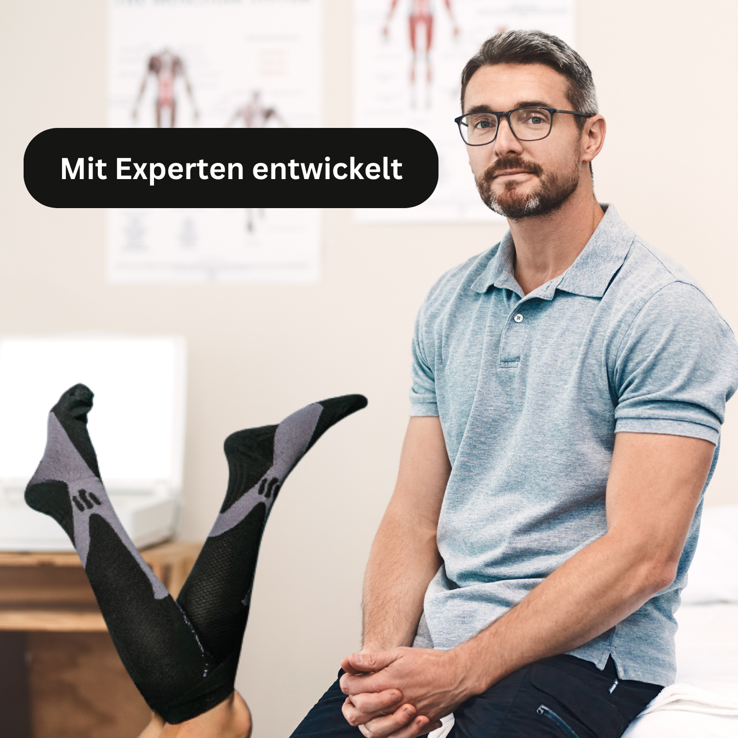 Ein Mann mit Brille und grauem Poloshirt sitzt in einer Arztpraxis. Im Vordergrund trägt jemand Tieberg™️ - Akupressur Kompressionsstrümpfe. In einer Textblase steht auf Deutsch "Mit Experten entwickelt".